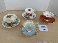 Four teacups and saucers arranged showing the illustrating designs and colors.