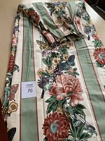 Folded drapery panels showing floral, butterfly patterns and striped background along with gathered top detail.