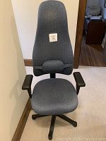 Front view of blue/gray office chair showing high backrest with lumbar support cushion and black armrests.