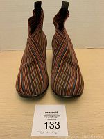 Front view of multi-colored vertical striped elastic booties with pointed toes and pull tabs.