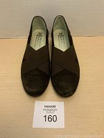 Front view of the pair of Mephisto women's brown slip-on shoes showing the criss-cross elastic detail and suede material.