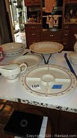 Photo showing the full set on a kitchen countertop including the serving plates, gravy boat, and metal stand.