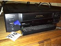Front view of Sony VCR with remote placed underneath showing power button, cable input eject, and VHS slot.