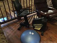 Side view of Cat Eye Ergociser EC-8000 semi recumbent bike and BOSU Balance Trainer on wooden floor.