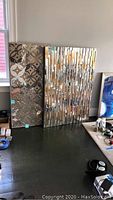 Two pieces of mirror art leaning against the wall, showing overall size and shape.