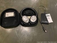 Photo showing Bose QuietComfort 2 headphones inside their original black zipper carrying case and the Seagate black portable hard drive with an attached USB-A cable