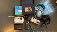 Overview photo showing all items including cameras, headphones, and Echo Dot box on table