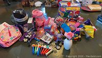 Wide view of all toys and items in the lot showing PEZ dispensers, MEGA BLOKS, night lights, and other toys arranged on a table.