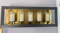 Front view of metal framed wall hanging candle holder with 5 glass-covered pillar candles