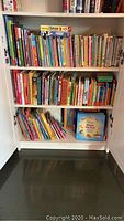 Full view of three bookshelves filled with children's books of varying sizes and colors