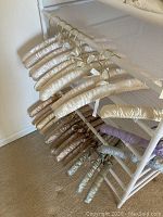 Silk padded hangers in multiple shades hanging from a drying rack