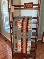 Blanket draped on wooden rack showing full geometric design