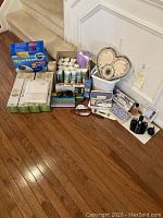 Full view of all items in the lot displayed on floor. Shows Vicks vaporizer box, beauty products, grooming kit, nail filer, and bath accessories.
