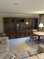 Full view of entertainment wall unit installed along wall, adjacent round table and chairs