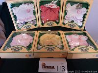 Six original boxed baby clothes for Cabbage Patch Kids dolls arranged in two rows of three. Boxes show some wear but clothes inside look new.