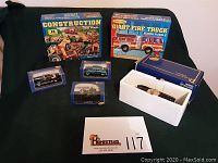 Two Melissa and Doug floor puzzle boxes (Construction and Giant Fire Truck) along with four American Mint die cast cars in packaging and one open box showing two cars inside.