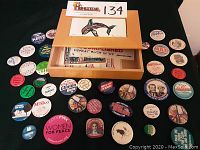 Wooden box with inset orca tile art with political buttons surrounding and contained inside.