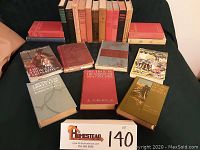 All books laid out showing varying colors and conditions, grouped on black surface.