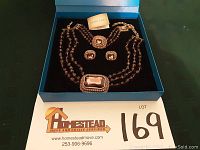 Heidi Daus jewelry set displayed in original blue box with black velvet interior, showing necklace, bracelet, earrings and brand card.