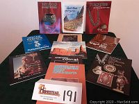 Eleven Native American and Western Americana paperback books arranged on a black surface showing front covers featuring pottery, landscapes, jewelry, and art.