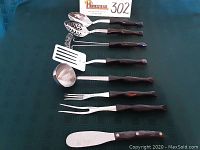 Eight utensils laid flat side by side showing full lengths and handles