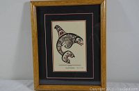 Full view of the framed indigenous print featuring a stylized killer whale and wooden frame.