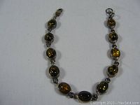 Top view of the amber and sterling silver bracelet showing oval amber stones set in silver links.