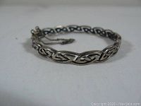 Silver bracelet displayed showing the intricate Celtic knot pattern and overall shape.