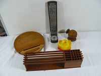 Wide angle photo showing all the items in the lot, various teak wooden pieces and colorful egg cups arranged on a white cloth.