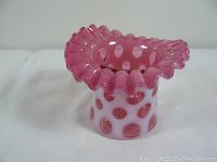 Angled side view of the cranberry coin dot glass vase with ruffled edge, showing dot pattern and glass texture.