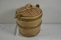 Front angle of vintage McCoy ceramic cookie barrel designed to look like a wood barrel with three metal bands and a rope handle on lid.