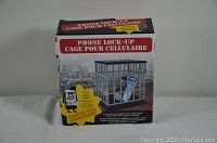 Photo of the front of the box showing the phone lock-up cage with the phone inside and the lock feature.