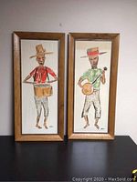 Photo of both framed paintings together showing full compositions and frames.