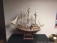 Front full view of the entire matchstick ship on stand showing three masts with sails and rigging