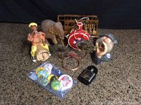 Entire lot including figurines, flask, buttons, copper fish, elephant, leather bottle, and streetcar model