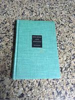 Front cover of the hardback book showing turquoise textured cover with black label and title.