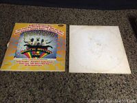 Front covers of Beatles albums - Magical Mystery Tour cover colorful with band pictured and White Album plain white with faint embossing