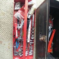 Open toolbox with visible socket wrenches, adjustable wrenches, a level, and other hand tools arranged in compartments