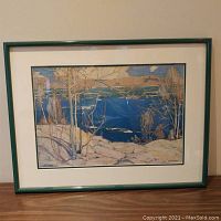 Full view of framed print showing Tom Thomson winter landscape artwork with snow, trees, and lake.