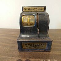 Front view showing mechanical counter, coin slot, and front label with coin denominations and branding.