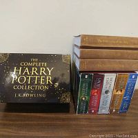 Books and boxed set arranged to show Harry Potter boxed set, hardcover Lord of the Rings books with worn spines, and George R.R. Martin paperback books together.