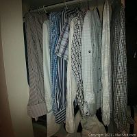 Eight men's medium dress shirts on hangers, showing variety of patterns and colors such as stripes and checks.