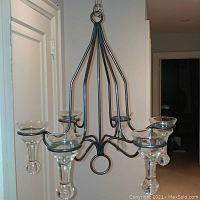 Full view of one chandelier showing six arms with attached handmade glass candle holders.