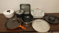 Full overview of all cooking and baking items included in the lot, showing skillet, colander, salad spinner, baking dishes and pans.