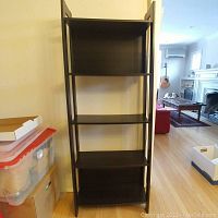 Front view of the dark wood 5-shelf Ikea bookcase showing all five shelves and the overall structure.