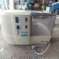 Side view of Duracraft humidifier showing power and humidistat controls, water tank, and power cord.