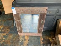 Full view of the rectangular metal framed mirror placed on the floor showing overall design and size.