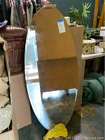 Full oval mirror showing size and setting among other household items.