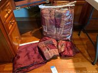 Queen bedding set including comforter, pillow shams, and bed skirt. Visible folded comforter in clear packaging.