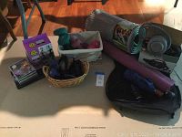 Full view of workout equipment including hand weights, yoga mats, chair massage pad, electric air pump, umbrella, and music CDs spread on floor.